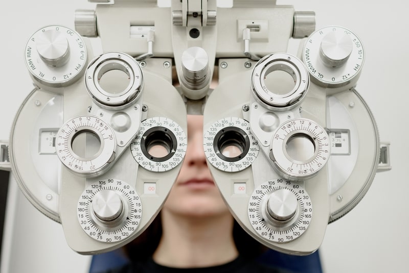 moteris tikrinasi regėjimą pas oftalmologą